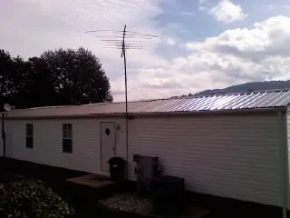 New metal roof on a single wide mobile home with a TV antenna in Lancaster